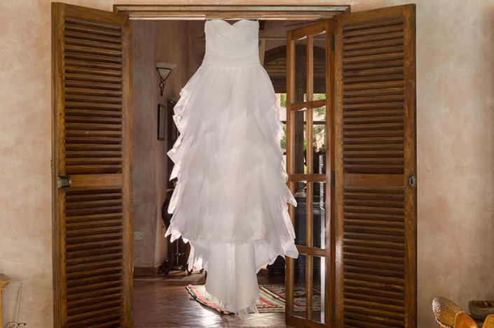 This Photo shows the brides wedding dress hanging from the door frame